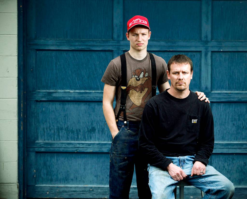 Dayn Brunner and his son Riley (age 17 at the time) pose for a photo at Darrington High School on March 12, 2015. Dayns sister, Summer Raffo, was one of the 43 victims of the Oso mudslide. Dayn and Riley spent five days searching the debris field before finding Summer in her car, hands still on the steering wheel. Dayn spent a total of 39 days searching through the mud for other victims. (Genna Martin / Herald file)