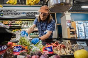 Ryan Welch, a produce clerk, restocks grapes at the Sno-Isle Food Co-op on Friday, Sept. 17, 2021 in Everett, Wa. (Olivia Vanni / The Herald)