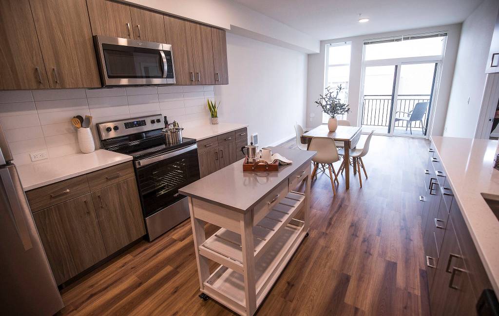 A kitchen and living room in a two bedroom unit of the Marquee Apartments in Everett. (Andy Bronson / The Herald)