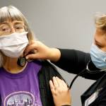 Deena Jones is examined by Briana Brewer at UW Medicine in Seattle on Sept. 30. (Kevin Clark / The Herald)