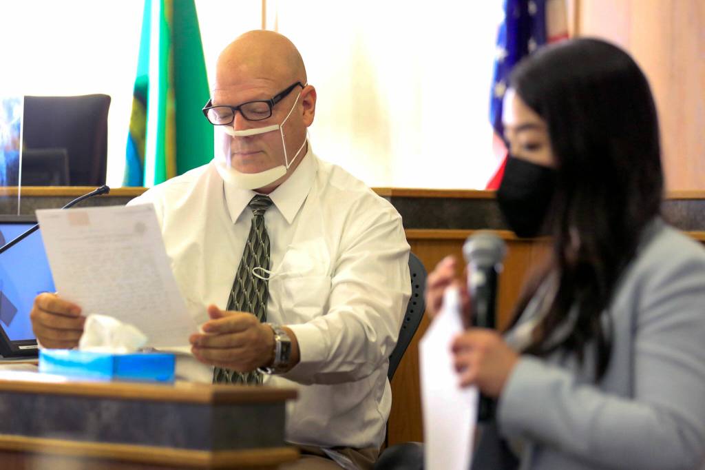 Mark Bond, a retired Snohomish County sheriffs deputy, looks over evidence with deputy prosecutor prosecuting Martina Wong, right, Friday morning during the trial of Jason Dominguez at the Snohomish County Superior Court in Everett on October 1, 2021. (Kevin Clark / The Herald)
