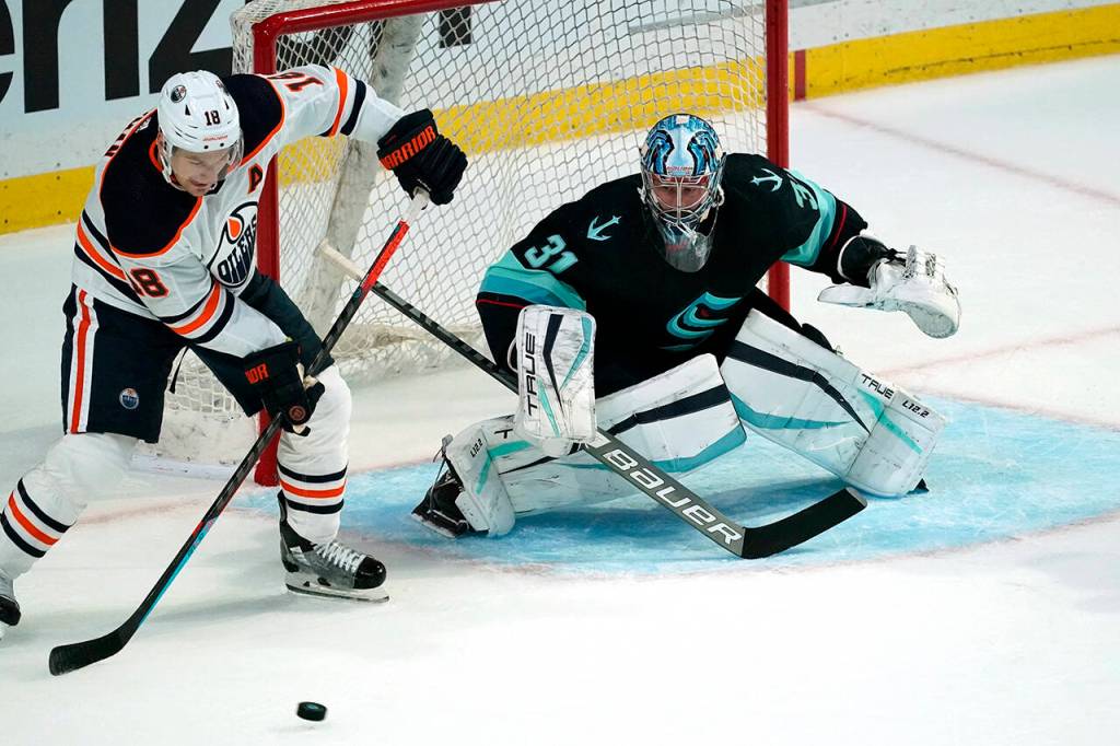 Seattle Krakens goalie Philipp Grubauer (31) eyes the puck as Edmonton Oilers Zach Hyman (18) moves in in front of the net in the first period of a pre-season NHL hockey game Friday in Everett. (AP Photo/Elaine Thompson)