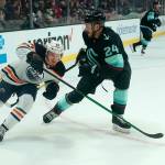 The Oilers James Hamblin (left) skates past the Krakens Jamie Oleksiak in the first period of a preseason game Friday at Angel of the Winds Arena in Everett. (AP Photo/Elaine Thompson)