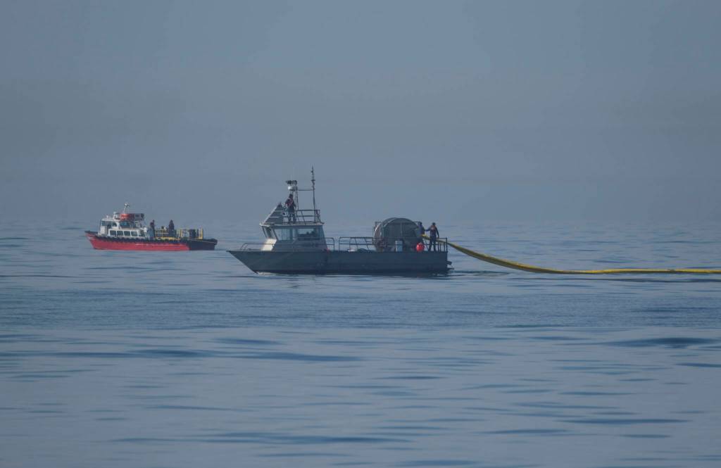 A Marine Spill Response Corporation (MSRC) vessel, foreground, an oil spill removal organization (OSRO), deploys floating barriers known as booms to try to stop further incursion of an oil slick off Huntington Beach, Calif., Sunday., Oct. 3, 2021. A major oil spill off the coast of Southern California fouled popular beaches and killed wildlife while crews scrambled Sunday to contain the crude before it spread further into protected wetlands. (AP Photo/Ringo H.W. Chiu)