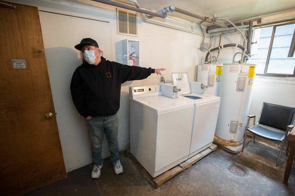Stephen Teixeira documents the issues at the Grand Apartments, describing how two water heaters are used to supply 14 units with hot water, and that the laundry is unusable to residents . (Andy Bronson / The Herald)