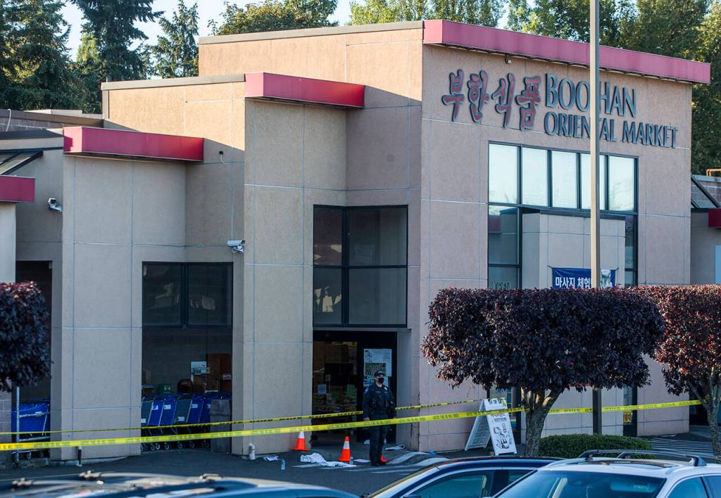 A police officer on Sept. 29, 2020, stands outside the Boo Han Oriental Market in Edmonds, where Duy Phuong Nguyen shot three people, killing one of them. (Olivia Vanni / Herald file)