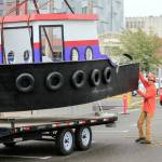 A model tugboat exhibit is hoisted Sept. 27 into the expansion of the Imagine Childrens Museum in Everett. (Kevin Clark / The Herald)
