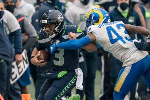 Seattle Seahawks quarterback Russell Wilson is pushed out of bounds by Los Angeles Rams safety John Johnson III during the first half of an NFL wild-card playoff football game, Saturday, Jan. 9, 2021, in Seattle. The Rams won 30-20. (AP Photo/Stephen Brashear)