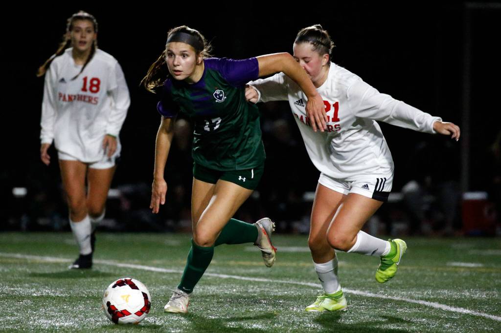 Edmonds-Woodways Melia Plumis, center, and Snohomishs Katherine Kennedy chase down a loose ball Thursday night at Edmonds-Woodway High School in Edmonds on October 7, 2021. (Kevin Clark / The Herald)