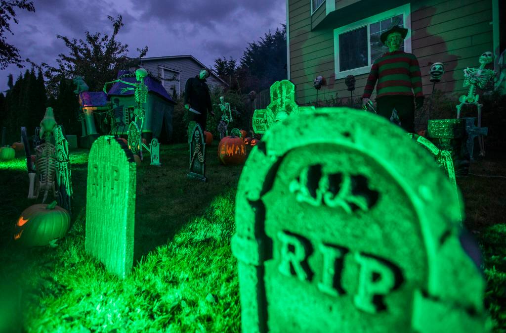 John Morrison, as Michael Myers, and Michael Smith, as Freddy Krueger, check out the Halloween scene in front of Brandi Smiths home in Arlington. (Olivia Vanni / The Herald)