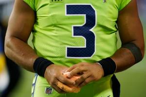 Seattle Seahawks quarterback Russell Wilson holds a sponge near his taped injured finger during the fourth quarter of an NFL football game against the Los Angeles Rams, Thursday, Oct. 7, 2021, in Seattle. Wilson left the game after the injury and the Rams won 26-17. (AP Photo/Elaine Thompson)