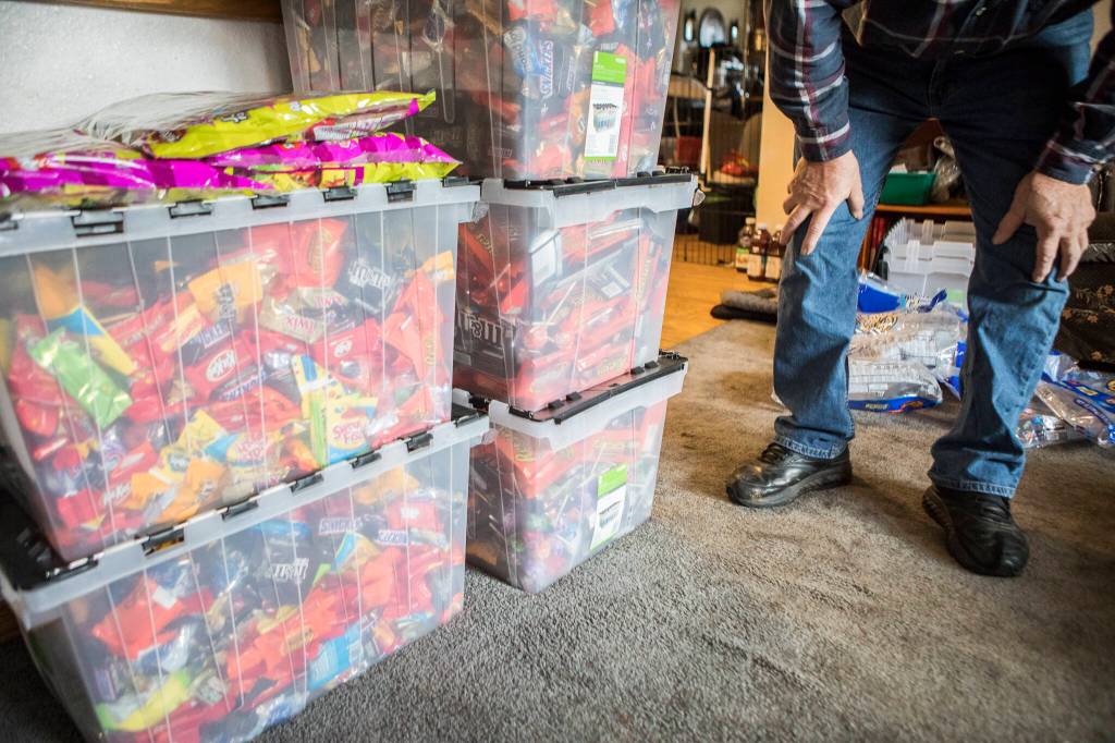 Stephen Fay counts the full bins of candy at his home Friday in Marysville. (Olivia Vanni / The Herald)