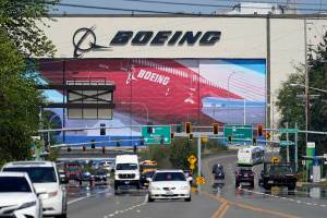 Traffic drives in view of a massive Boeing Co. production plant, where images of jets decorate the hangar doors, Friday, April 23, 2021, in Everett, Wash. (AP Photo/Elaine Thompson)