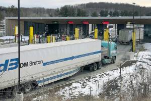 FILE - In this Wednesday, March 18, 2020 file photo, truck traffic from Canada waits to cross the border into the United States in Derby Line Vt. The U.S. will reopen its land borders to nonessential travel next month, ending a 19-month freeze due to the COVID-19 pandemic as the country moves to require all international visitors to be vaccinated against the coronavirus. The new rules, to be announced Wednesday, Oct. 13, 2021 will allow fully vaccinated foreign nationals to enter the U.S. regardless of the reason for travel (AP Photo/Wilson Ring, File)