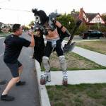 Dressed as Gene Simmons of Kiss fame, Everett firefighter and paramedic Jack Murrin and neighbor John Tanaka greet each other out on the street as Murrin heads out to a open mic session at Cafe Zippy in 2017 in Everett. (Andy Bronson / The Herald)