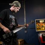 Gene Simmons impersonator, Jack Murrin practices on there bass guitar at his storage building on Thursday, Oct. 21, 2021 in Everett, Washington. Murrin, 51, a firefighter and impersonator, is putting on a 2-hour KISS concert with 19 songs in front of his north Everett home on Halloween.  (Andy Bronson / The Herald)