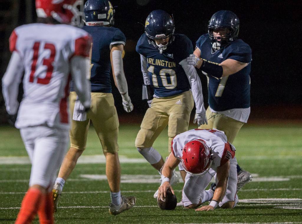 Arlingtons Andrew Bryant stands over Marysville-Pilchucks Jordan Velasquez after tackling him Friday during the game in Arlington. (Olivia Vanni / The Herald)