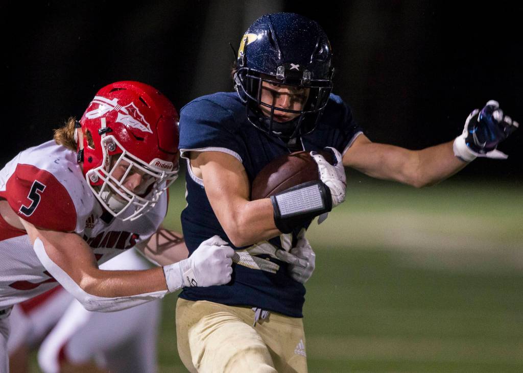 Arlingtons Holden Erken is tackled by Marysville-Pilchucks Dylan Carson during the game Friday in Arlington. (Olivia Vanni / The Herald)