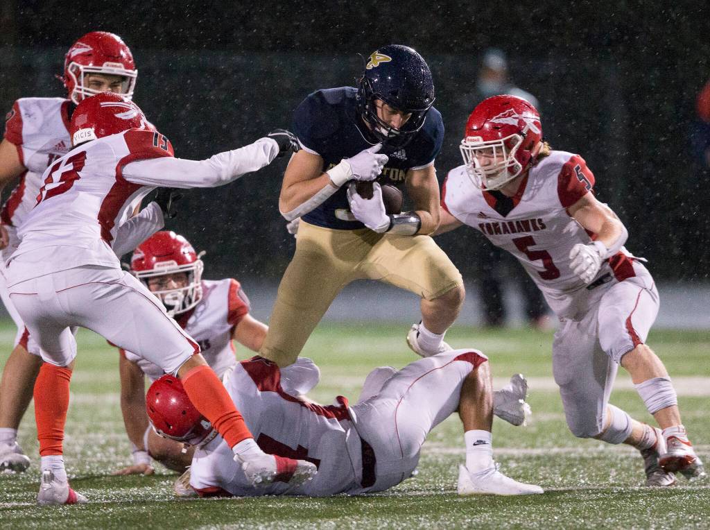 Arlingtons Gage Price leaps over a Marysville-Pilchuck player Friday during the game in Arlington. (Olivia Vanni / The Herald)