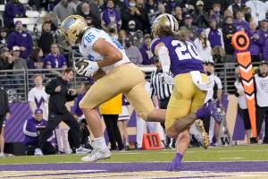 UCLA tight end Greg Dulcich scores a touchdown next to Washington defensive back Asa Turner during the second half of an NCAA college football game Saturday, Oct. 16, 2021, in Seattle. (AP Photo/Ted S. Warren)