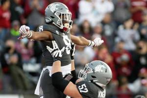 Washington State offensive lineman Jarrett Kingston (52) lifts wide receiver Calvin Jackson Jr. while celebrating Jackson's touchdown during the first half of an NCAA college football game against Stanford, Saturday, Oct. 16, 2021, in Pullman, Wash. (AP Photo/Young Kwak)