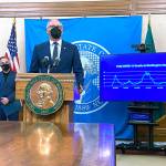 Washington Gov. Jay Inslee talks to reporters in Olympia on Oct. 14, as Secretary of Health Umair Shah looks on. Inslee announced that starting Nov. 15, people in the state will need to either provide proof of COVID-19 vaccination or a negative test in order to attend large events. (AP Photo/ Rachel La Corte)