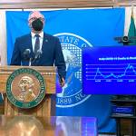 Washington Gov. Jay Inslee, front, talks to reporters in Olympia, Wash., Thursday, Oct. 14, 2021, as Secretary of Health Umair Shah looks on. Inslee announced that starting Nov. 15, people in the state will need to either provide proof of COVID-19 vaccination or a negative test in order to attend large events. (AP Photo/ Rachel La Corte)