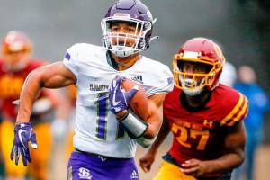 Lake Stevens' Jayden Limar races for additional yardage after a reception with O'Dea's Trey Stokes trailing Friday at Memorial Stadium in Seattle on September 17, 2021. The Vikings defeated the Irish, 20-3. (Kevin Clark / The Herald)