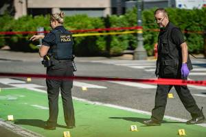 FILE - In this July 17, 2021, file photo, police investigate an overnight fatal shooting in Portland, Ore. Portland is on track to shatter its record of 70 homicides set in 1987. The city's police department is struggling to keep up amid an acute staffing shortage and budget cuts. (Mark Graves/The Oregonian via AP, File)