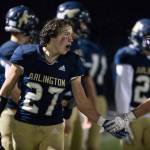 Arlingtons Holden Erken yells and high-fives a teammate after beating Marysville-Pilchuck on Oct. 15, 2021, in Arlington. (Olivia Vanni / The Herald)