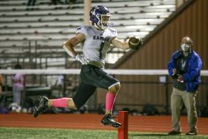 Kamiak's Wesley Garrett leaps into the end zone for the touchdown as Kamiak beat Mariner 41-14 in a football game at Goddard Stadium on Tuesday, Oct. 19, 2021 in Everett, Washington.  (Andy Bronson / The Herald)
