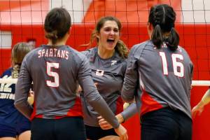 Stanwood's Baylor Hezel, left to right, Olivia Rueckert and Grace Henken celebrate a point against Arlington Thursday night at Stanwood High School on October 21, 2021.  (Kevin Clark / The Herald)