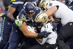 Seattle Seahawks defensive end Rasheem Green (94) brings down New Orleans Saints running back Alvin Kamara (41) during the first half of an NFL football game, Monday, Oct. 25, 2021, in Seattle. (AP Photo/Ted S. Warren)