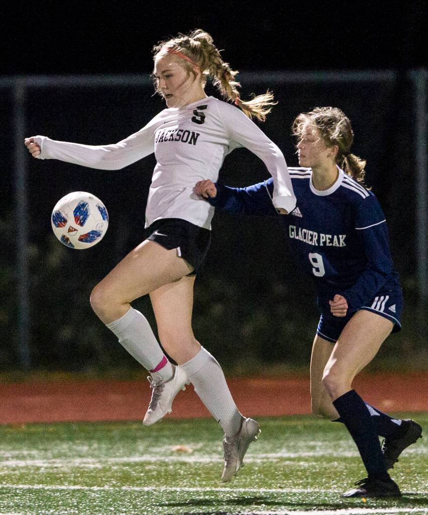 Jacksons Avery Friedricksen jumps to trap the ball during the game against Glacier Peak on Tuesday in Snohomish. (Olivia Vanni / The Herald)