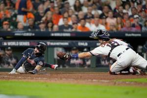 Atlanta Braves' Dansby Swanson scores past Houston Astros catcher Jason Castro on a sacrifice fly during the eighth inning of Game 1 in baseball's World Series between the Houston Astros and the Atlanta Braves Tuesday, Oct. 26, 2021, in Houston. (AP Photo/David J. Phillip)