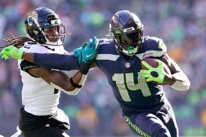 Seattle Seahawks' DK Metcalf (14) pushes off of Jacksonville Jaguars' Rayshawn Jenkins as he runs with the ball during the first half of an NFL football game, Sunday, Oct. 31, 2021, in Seattle. (AP Photo/Ted S. Warren)