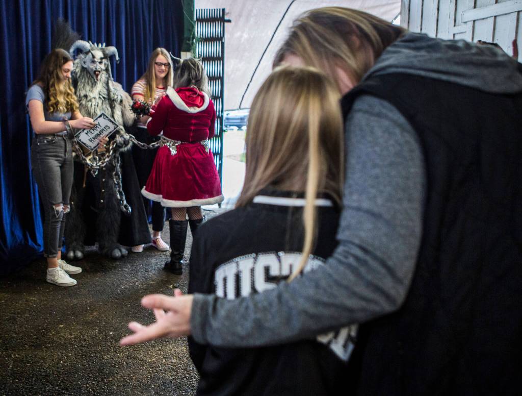 A young girl is convinced by her mother to take a photo with Krampus at the last Oddmall Emporium of the Weird in 2019 in Monroe. (Olivia Vanni / Herald file)