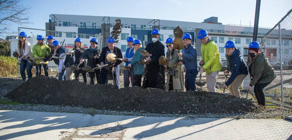 Dirt flies as VIPs break ground on a new retail site at Fishermans Harbor at Waterfront Place on Monday at the Port of Everett. (Andy Bronson / The Herald)