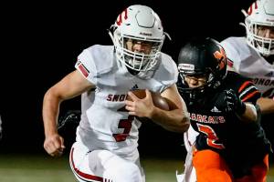 Snohomish's Joshua Vandergriend rushes with Monroe's Wahi Emmsley closing Friday night at Monroe High School on October 22, 2021.  (Kevin Clark / The Herald)