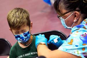 Wren Nagata, 7, of Pasadena grimaces as he receives his COVID-19 vaccine from Jacqueline Valdez during an event kicking off coronavirus vaccinations for children age 5-11 at Eugene A. Obregon Park in Los Angeles on Wednesday, Nov. 3, 2021. (Keith Birmingham/The Orange County Register via AP)