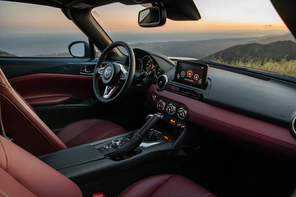 The 2021 Mazda MX-5 Miatas tablet-style infotainment screen is controlled by a rotary dial on the center console. The Miata RF interior is shown here. (Manufacturer photo)