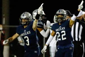 Glacier Peak's Ashton Olson and Reggie Valmonte signal a turnover against Skyline Friday night at Veterans' Memorial Stadium in Snohomish on November 5, 2021. (Kevin Clark / The Herald)