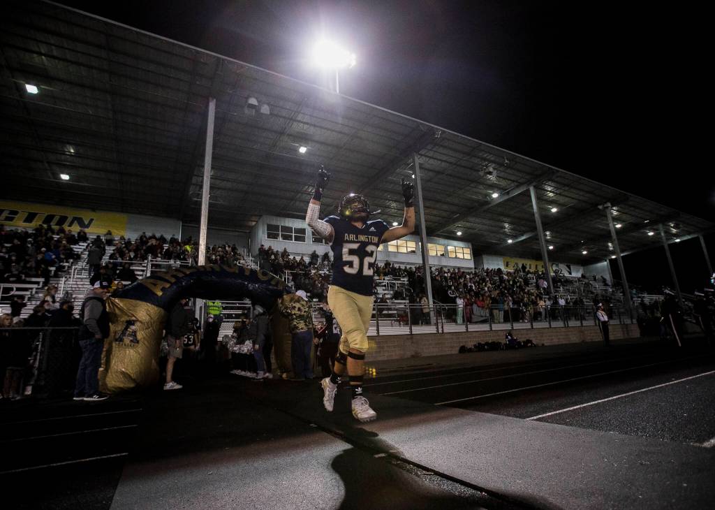 Arlingtons Quintin Yon-Wagner runs out onto the field before the start of the game against Auburn Mountainview on Friday, Nov. 5, 2021 in Arlington, Wa. (Olivia Vanni / The Herald)