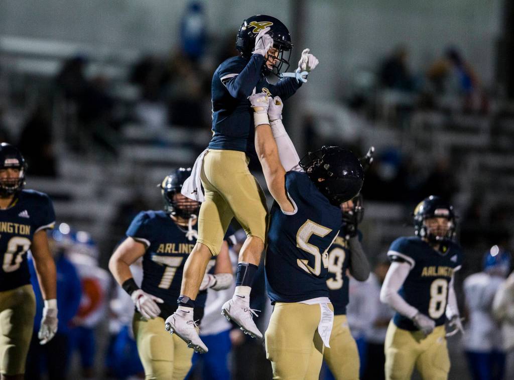Arlingtons Nolan Welch lifts up Levi Younger in celebration of his touchdown during the game against Auburn Mountainview on Friday, Nov. 5, 2021 in Arlington, Wa. (Olivia Vanni / The Herald)