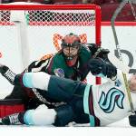 Seattle Kraken right wing Jordan Eberle, right, falls to the ice over Arizona Coyotes goalie Scott Wedgewood, left, during the first period of an NHL hockey game Saturday, Nov. 6, 2021, in Glendale, Ariz. (AP Photo/Ross D. Franklin)