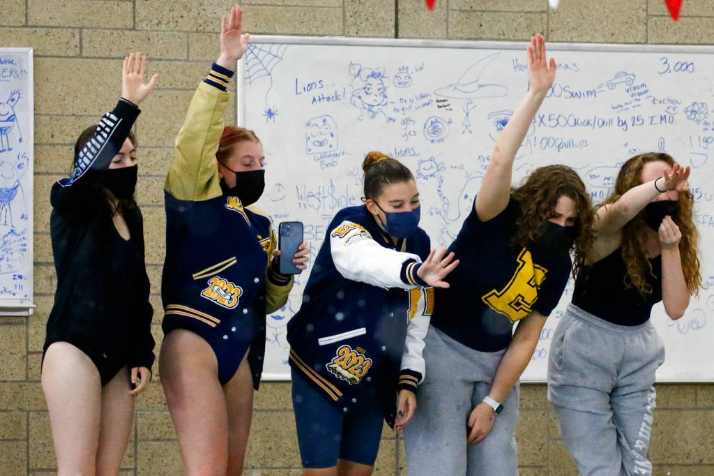 Members of the Everett swim team cheer on Summer Dean during the 3A District Championships Saturday afternoon the at the Snohomish Aquatic Center on November 6, 2021. (Kevin Clark / The Herald)