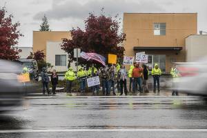 People hold signs in protest of the vaccine mandate along Airport Road next to Boeing on Friday, Oct. 15, 2021 in Everett, Wa. (Olivia Vanni / The Herald)