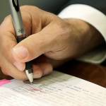Washington Gov. Jay Inslee uses a red pen to veto sections of the state operating budget, Tuesday, May 21, 2019, at the Capitol in Olympia, Wash. Inslee signed the state's capital, operating, and transportation budgets Tuesday, officially designating funds — and new taxes — to pay for state programs for the next two years. (AP Photo/Ted S. Warren)