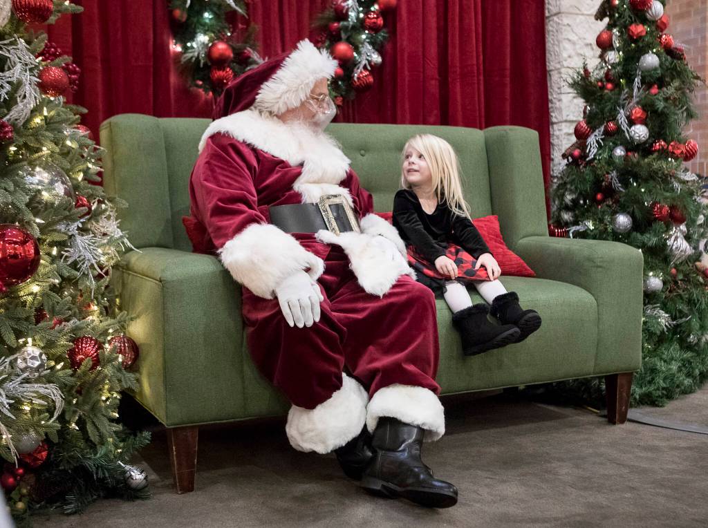Dylan Blaney, 3, talks with Santa about what she wants for Christmas at the Santa Magic experience at Alderwood Mall on Friday, Nov. 19, 2021 in Lynnwood, Wa. (Olivia Vanni / The Herald)