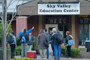 In this Jan. 4, 2019 photo, workers and other officials gather outside the Sky Valley Education Center school in Monroe, Wash., before going inside to collect samples for testing. The samples were tested for PCBs, or polychlorinated biphenyls, as well as dioxins and furans. A lawsuit filed on behalf of several families and teachers claims that officials failed to adequately respond to PCBs, or polychlorinated biphenyls, in the school. (AP Photo/Ted S. Warren)